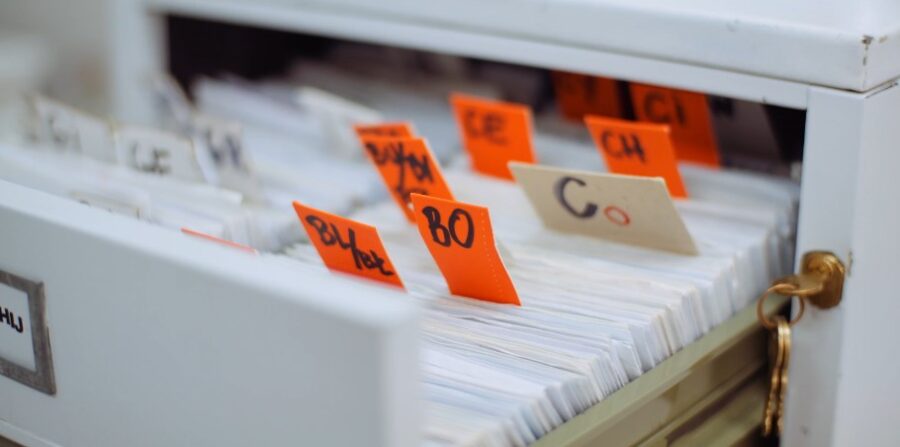 Orange labels identify specific documents within the filing cabinet
